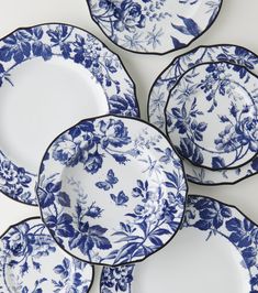 six blue and white plates stacked on top of each other, with flowers painted on them