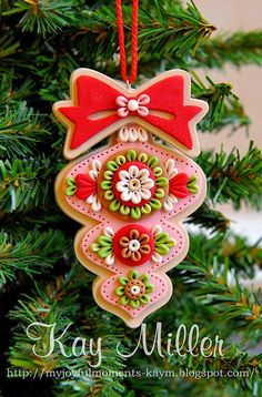 an ornament hanging from a christmas tree decorated with red and green decorations,