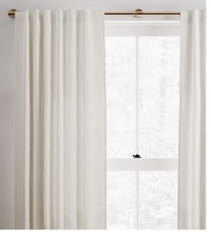 a white curtain hanging in front of a window