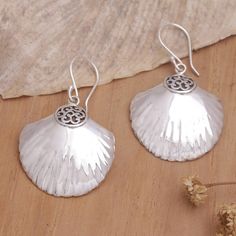 Luminous seashells are the centerpiece of Balinese artisan Putu Putri's newest design. These sterling silver dangle earrings feature a gorgeous design embellished with little Balinese motifs and a combination finish, adding an elegant touch to the accessory. Silver Ocean-inspired Earrings, Nickel-free Silver Ocean-inspired Earrings, Sterling Silver Shell Earrings For Gift, Sterling Silver Shell As Gift, Ocean-inspired Sterling Silver Drop Earrings, Silver Dangle Jewelry With Shell, Silver Nickel-free Shell-shaped Earrings, Elegant Silver Shell Earrings, Ocean-inspired Sterling Silver Dangle Earrings