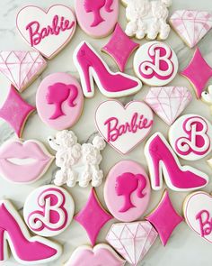 cookies decorated with pink and white icing are arranged in the shape of shoes, heels, and hearts