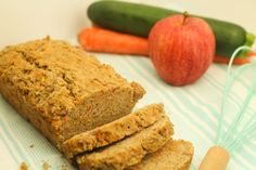 there are carrots, zucchini bread and an apple on the table next to it