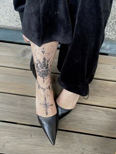 a woman's legs with tattoos on them