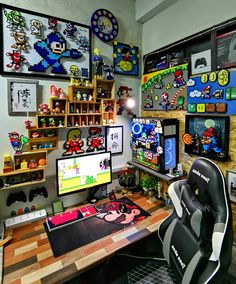 a gaming room with several computer screens and games on the wall, including mario kart