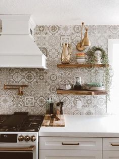 a stove top oven sitting inside of a kitchen next to wooden shelves filled with pots and pans