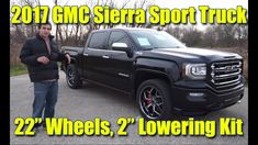 a man standing next to a truck with the words, 2017 gmc sierra sport truck