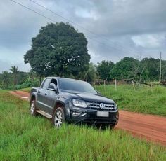 a truck is parked on the side of a dirt road