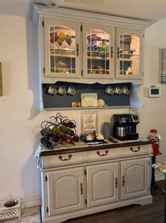 a kitchen with white cabinets and wooden floors