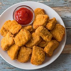 fried chicken nuggets with ketchup on a white plate