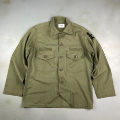 VINTAGE ' Military Army Faded Green Fatigue OG Button Down Shirt sz Lrg Adult CONDITION : Wear and fading from age. Stains/ marks around front, sleeves and back. Missing name patches. Great fading throughout. Overall good condition! This shirt has been washed* - Please review pictures* TAGGED SIZE : ** Mens Adult L** ( Fits : Mens L ) MEASUREMENTS : *Please see photos above for measurements. *Disclaimer: All measurements are in inches and are taken laying flat on the ground* *Please review pictu Military Style Long Sleeve Shirt With Buttons, Cotton Long Sleeve Camp Shirt With Button Closure, Green Military Button-up Top, Military Button-up Shirt, Military Style Button-up Tops, Military Style Button-up Tops With Snap Buttons, Long Sleeve Cotton Camp Shirt With Buttons, Military Style Collared Top With Snap Buttons, Military Style Long Sleeve Top With Button Closure