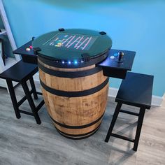 a wooden barrel with a chalkboard on it and three stools next to it