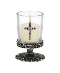 a glass candle holder with a cross on it