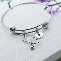 "Personalized Stethoscope charm bracelet is a unique design and makes a great gift! ➸CHARMS: -Antique Silver Stethoscope: 23x15mm -You choose the Initial Letter: 10mm Stainless Steel bangle bracelet is an expandable wire material. Non-tarnishing and great for those with a sensitivity to metals! [Available in 3 sizes] -SMALL: 6-7\" wrist -MEDIUM: 7-8\" wrist, and 2.5\" in diameter -LARGE: 8-9\" wrist ❤️Packaging: Your purchase will be in a nice ORGANZA Bag ready for gift giving. Gift box availabl Personalized Stethoscope, Stethoscope Charms, Gift For Nurse, Nurse Doctor, Jewelry Personalized, Stainless Steel Bangles, Gift For Brother, Star Gift, Birthstone Charms