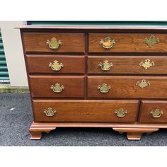 a large wooden dresser with brass handles and knobs on it's drawers,