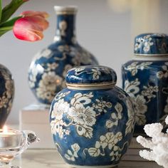 blue and white vases sitting on top of a table next to a tea light holder