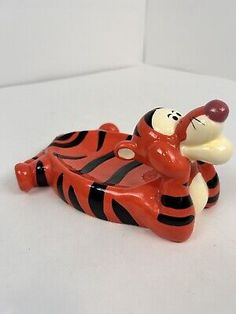 a ceramic figurine of a cartoon character laying on its back with his mouth open