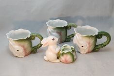 four ceramic mugs with animals in them