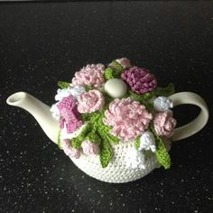 a crocheted tea pot with flowers on it