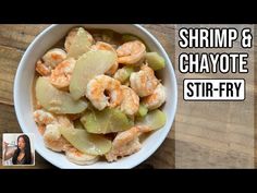 shrimp and ghayote stir - fry in a white bowl on top of a wooden table