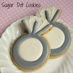 two decorated cookies on a plate with the words sugar dot cookies written in white and blue