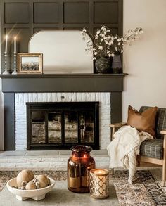 a living room filled with furniture and a fire place in front of a mirror on the wall