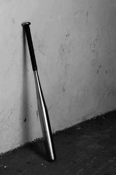 a baseball bat leaning up against a wall