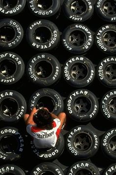 a man sitting on top of a pile of tires