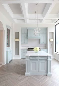 a large kitchen with an island in the middle and white cabinets on either side of it