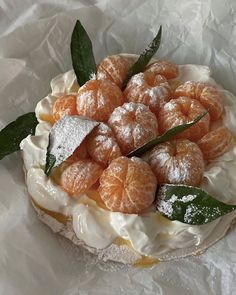 an orange dessert is topped with powdered sugar and green leafy garnish