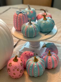 painted pumpkins are displayed on three tiered plates