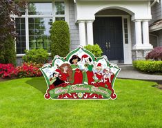 a christmas sign in front of a house with santa's helpers on it