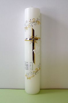 a white candle with a cross on it