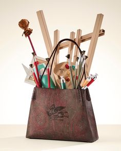 a bag filled with lots of different types of art supplies in it's holder