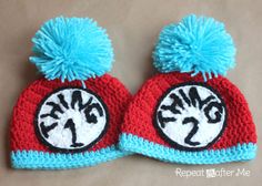 the cat in the hat crocheted beanie is red and white with blue pom - poms