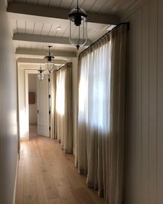 an empty hallway with curtains hanging from the ceiling