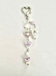 a key chain with flowers and hearts hanging from it's side on a white surface