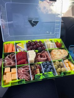 a lunch box filled with lots of different types of cheeses and fruits in it