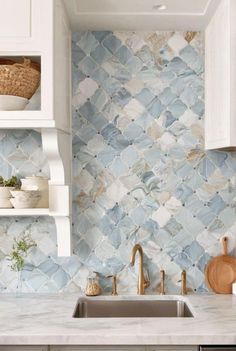 a kitchen with blue and white tile backsplashing, wooden utensils