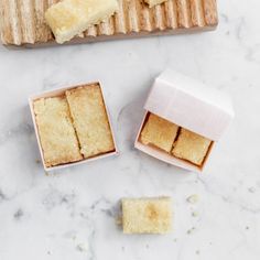 two slices of cake sitting on top of a wooden cutting board next to another piece of cake