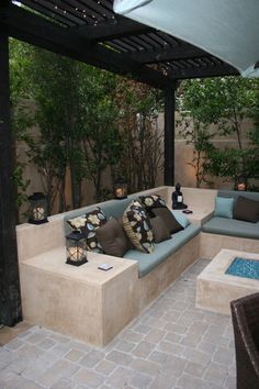 an outdoor living area with couches and pillows