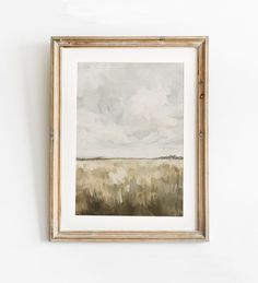 a painting hanging on the wall next to a white wall with a wooden framed frame