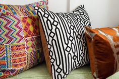 three decorative pillows are lined up on a bed