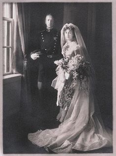 an old black and white photo of a man in uniform standing next to a bride