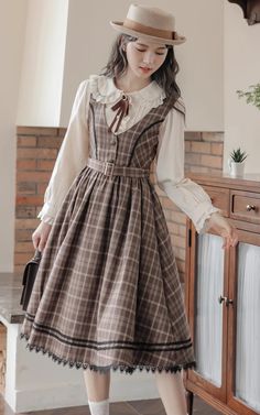 Plaid pinafore dress with a v-neckline, button down front, belted waist and midi skirt with black lace trims. Concealed side zipper. Matching blouse available with a peter pan collar, lace trims and neck detail.  BlouseS: 14.5” across shoulders, 35" chest, 22" lengthM: 15” across shoulders, 36.5" chest, 22" lengthL: 15 Plaid Pinafore Dress, Academia Dress, Midi Dress Brown, Wardrobe Revamp, People Reference, Diy Lipstick, Elegant Clothing, Nylon Dress, Cottagecore Outfits