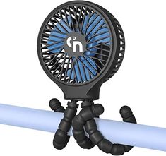 a blue and black fan sitting on top of a pipe