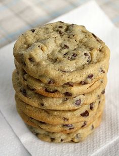 a stack of chocolate chip cookies sitting on top of a white napkin