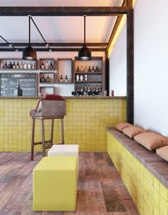 a yellow tiled bar with stools in front of it