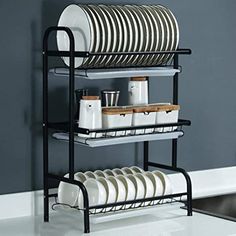 the dish rack is full of dishes and plates in black, with two shelves on each side