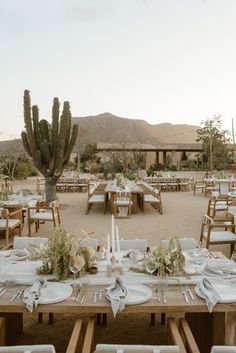 an outdoor dining area with tables and chairs set up for a meal in the desert