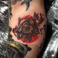 a close up of a person's leg with tattoos on it and a wolf